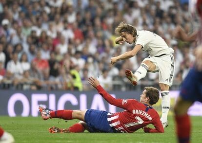 Luka Modric lanza el balón ante Griezmann.