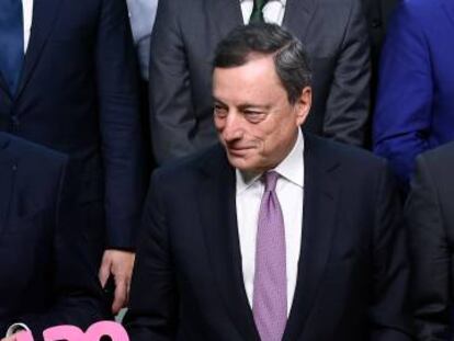 Mario Draghi, presidente del Banco Central Europeo, muestra una reproducción del euro. 