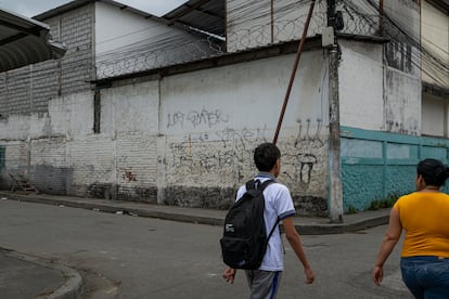 Un alumno camina a su escuela, protegida con alambres de púas, en Guayaquil. 