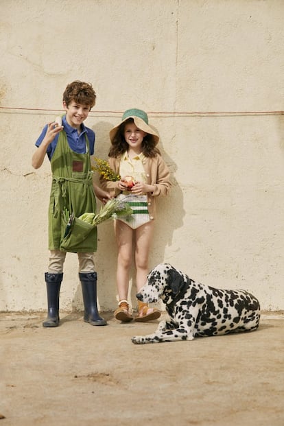 <b>Nicolás</b> lleva polo azul de Blauer, pantalón beis de Nicoli, botas de agua de Igor y mandil de lino de Los Peñotes. <b>Olivia</b>, cárdigan de cachemir de Caramel Baby & Child, blusa de bambula de Bonnet à Pompon, culote de punto de Piupiuchick, calcetines con volante de Bobo Choses, sandalias de piel de Pisamonas y sombrero de paja de Bobo Choses.