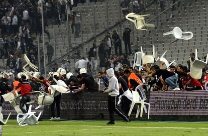 Los aficionados del Besiktas la emprenden a sillazos contra los antidisturbios durante un partido contra el Galatasaray en Turquía.