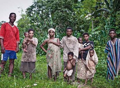 Los Angoula, familia de pigmeos baka que habita en la reserva de Dja, en Camerún, son propiedad de Romeo Ninty (jefe bantú, con camiseta roja). También le pertenecen los Wombo, los Ngopka, los Mbelanga. "No pueden irse porque trabajan para mí", dice Ninty.