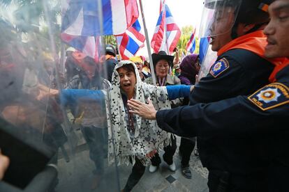 Agentes de la policía antidisturbios, tratan en vano de detener a un grupo de manifestantes contra el gobierno en el asalto a un edificio de oficinas, durante un mitin en el Departamento de Investigaciones Especiales (DSI) a las afueras de Bangkok, Tailandia. Cerca de 5.000 manifestantes tomaron parte en la manifestación y luego irrumpieron en el edificio de oficinas de DSI, la DSI ha acusado a los líderes de la protesta en manifestantes ilegales y han congelado sus cuentas bancarias la semana pasada.