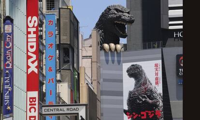 Cartel de 'Nuevo Godzilla' bajo la cabeza del monstruo de la película, en Tokio.