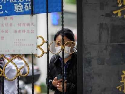 Una residente de Shanghái espera un reparto de alimentos en el interior de su complejo residencial, confinado debido a la covid.