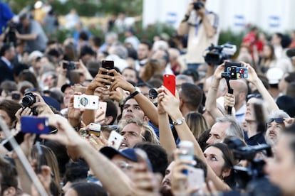 Fans toman fotografías a las estrellas que pasan por la alfombra roja durante la inauguración del festival de cine de Venecia.