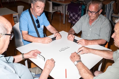 Un grupo de jubilados juegan al dominó en la cafetería del centro de mayores Ferrer i Guardia de Fuenlabrada.