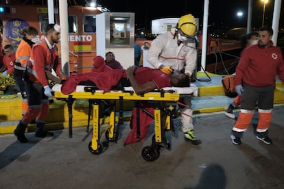 Fuentes de la Delegación del Gobierno en Melilla han informado de que entre los rescatados había tres niños y 10 mujeres. En la imagen, el personal de Cruz Roja traslada a tierra firme a uno de los náufragos.