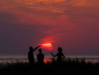 Disfrutando de la puesta de sol en el mar del Norte, en Cuxhaven, Alemania, el pasado 25 de julio. 