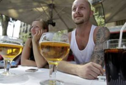 Unos turistas consumen unas cervezas en las terrazas de las populares Ramblas de Barcelona. EFE/Archivo