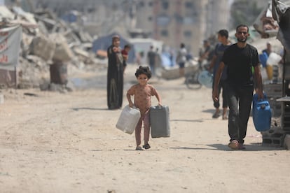 Un niño con dos bidones vacíos se dirige a recoger agua a un camión cisterna, este sábado en Ciudad de Gaza.