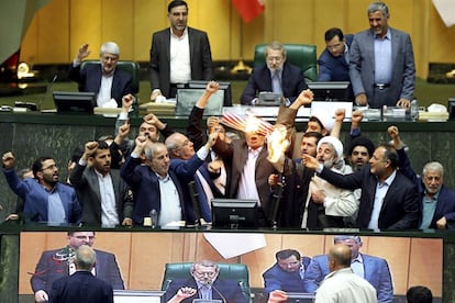Un grupo de diputados iraníes quema una bandera de EE UU en protesta por la decisión del presidente estadounidense, Donald Trump, de retirarse del pacto nuclear, durante una sesión en el Parlamento en Teherán (Irán).