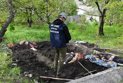 Un investigador observaba el miércoles los cuerpos exhumados del jardín de una casa de Stepanki, cerca de Járkov, en el este de Ucrania.