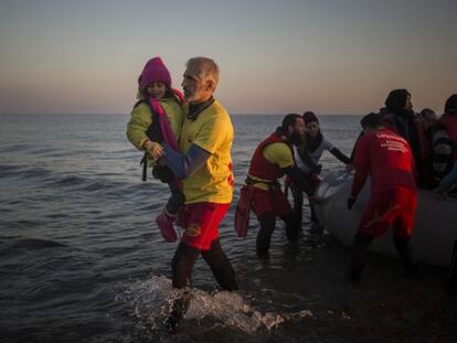 Enrique Álvarez ayuda el lunes a bajar a una niña refugiada en una playa cercana a la ciudad de Mytilene, en la isla de Lesbos.