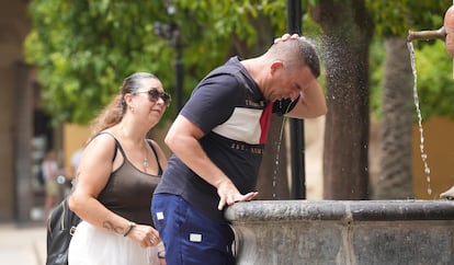 Una persona se refresca en una de las fuentes del Patio de los Naranjos durante una ola de calor en Córdoba el pasado julio.