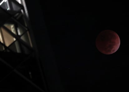 En México el eclipse ha comenzado a las 03.09 horas con la entrada de la luna a la umbra, la región más oscura de la sombra de la Tierra. En esta fase, que se ha extendido por más de una hora, el disco lunar desapareció gradualmente de la vista del observador terrestre conforme avanzó a través de la sombra. En la imagen, la 'luna de sangre' vista desde Ciudad de México.
