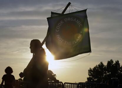 Un hombre sostiene una bandera durante la marcha por el clima en Nueva York. "Cocina orgánico, no el planeta", se lee en inglés.