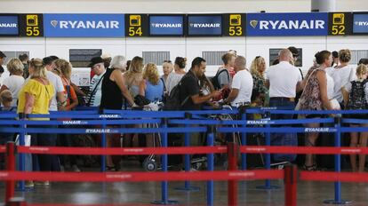 Decenas de viajeros hacen cola en el aeropuerto de Alicante en los mostradores de embarque de la compañía Ryanair.