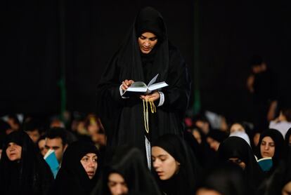 Un grupo de musulmanes iraníes rezan durante una ceremonia religiosa en el cementerio Behesht-Zahra, en el sur de Teherán (Irán).