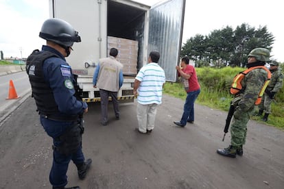 Policías y militares realizan una inspección a camiones de carga en el Estado de México.