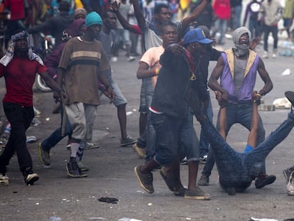 Los manifestantes arrastran el cuerpo de un compañero muerto hacia la policía, durante una protesta en Puerto Príncipe (Haiti).