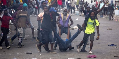 Los manifestantes arrastran el cuerpo de un compañero muerto hacia la policía, durante una protesta en Puerto Príncipe (Haiti).