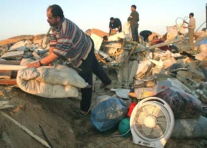 Varios palestinos recogen sus pertenencias en las ruinas de sus casas, destruídas por el Ejército israelí esta madrugada. En la operación falleció un anciano minusválido de 72 años.