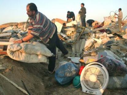 Varios palestinos recogen sus pertenencias en las ruinas de sus casas, destruídas por el Ejército israelí esta madrugada. En la operación falleció un anciano minusválido de 72 años.