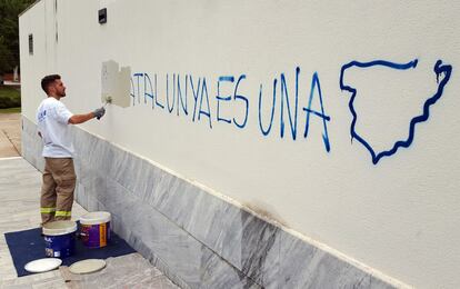 Un treballador tapa una pintada en un col·legi electoral a Sant Cugat del Vallès.