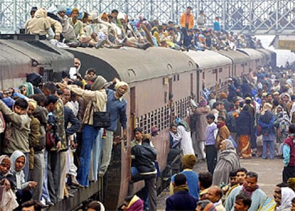 Peregrinos hindúes se arraciman en un convoy de ferrocarril en las inmediaciones de Alahabad para dirigirse a una celebración religiosa.

Un grupo de niños escarba en la basura almacenada en la orilla del río Yamuna, que pasa por Nueva Delhi.