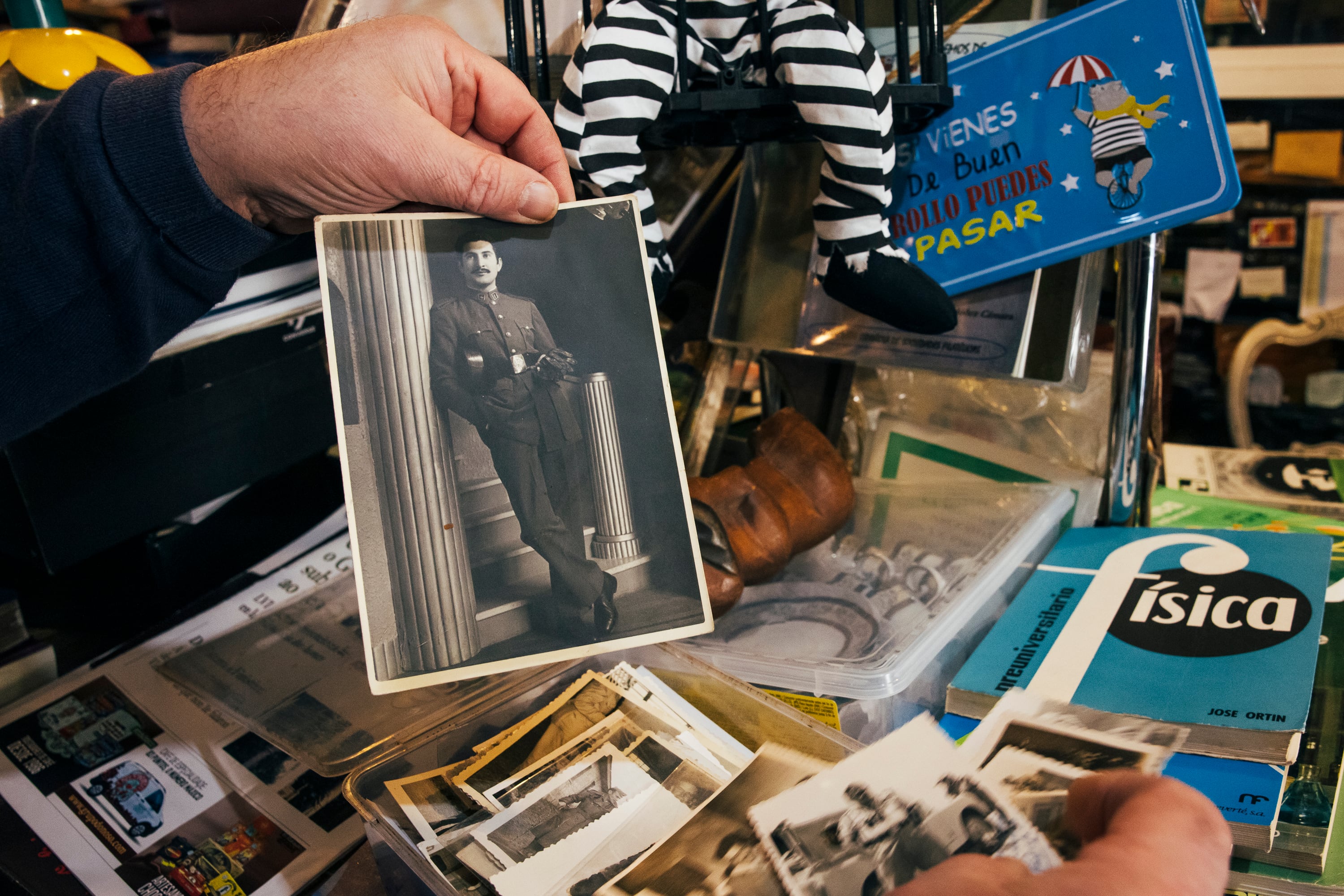 Carlos Rodríguez muestra fotografías históricas de militares de la guerra y la dictadura que han llegado a su tienda de Lugo.