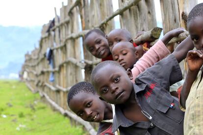 Unos niños congoleños juegan cerca de la valla que delimita el campo de refugiados de Nyakabande en Uganda, 9 de noviembre de 2013.