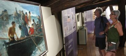 Unos visitantes observan los paneles de la exposición 'Galerna 1912-2012' en el Museo del Pescador.