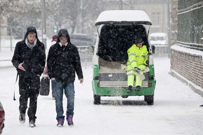 Una operaria del Ayuntamiento de Vitoria echa sal a las aceras para evitar que se forme hielo tras la nevada que ha caído esta noche.