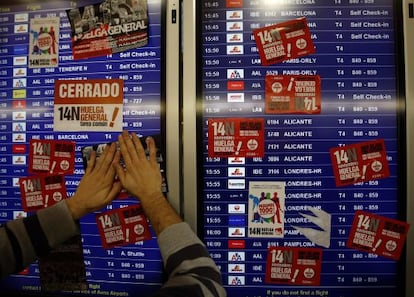 Un sindicalista pega carteles en el aeropuerto de Barajas, durante la huelga general