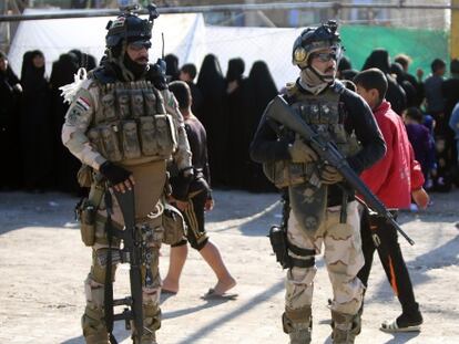 Soldados iraqu&iacute;es montan guardia mientras fieles chi&iacute;es celebran la Ashura en Bagdad, Irak