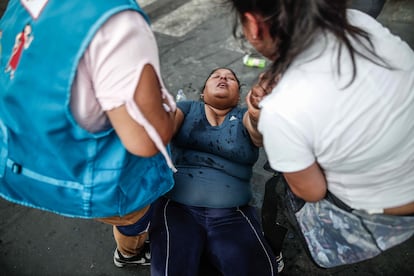 Una mujer se desmaya durante las manifestaciones en las calles del centro de Lima, el domingo. 