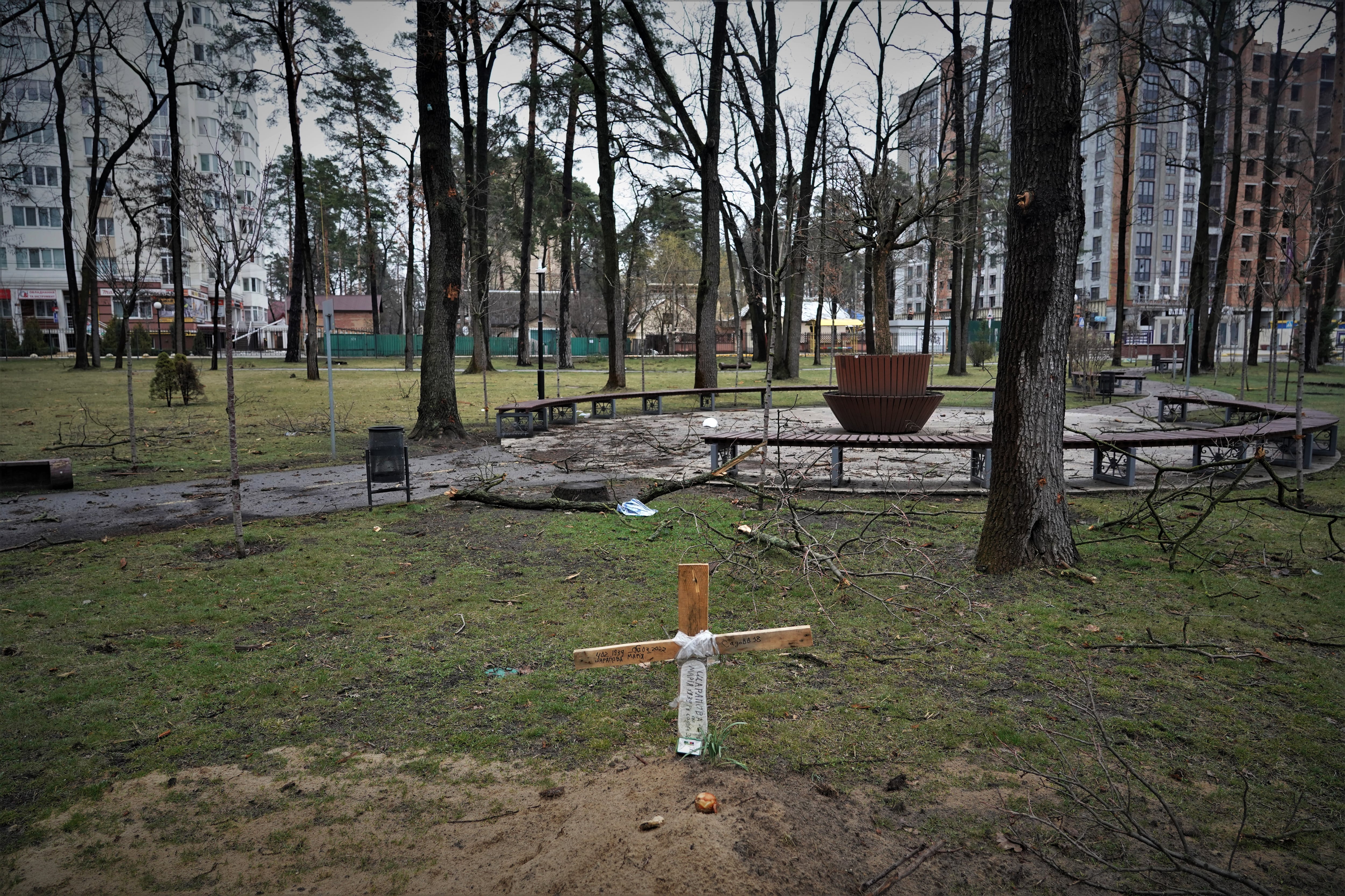 Una cruz de madera marca la tumba provisional de una ucrania en un parque de Irpín, a las afueras de Kiev, donde murió durante la ocupación rusa en marzo de 2022.