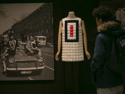 Un visitante observa un diseño de Devota & Lomba de 2016 junto a una foto de varias modelos en la calle Serrano (Madrid) en los sesenta.