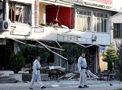 Expertos forenses inspeccionan las inmediaciones de un edificio destruido por la explosión registrada ayer en Pristina.