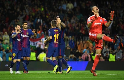 Lucas Digne celebra el tercer gol del Barcelona mientras el portero del Olympiakos Silvio Proto se lamenta.
