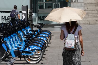 Una mujer se protege del sol con un paraguas mientras camina por el centro de Madrid, este martes.