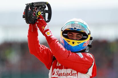 Fernando Alonso señala el escudo de Ferrari de su volante celebrando la victoria en el Gran Premio de Silverston, su primera victoria de la temporada.