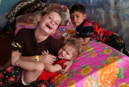 Un grupo de niños iraquíes juega y ríe sobre los colches del refugio temporal de Ainkawa.