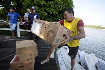 O transporte de urnas eletrônicas foi mais complicado no norte do país, onde as urnas tiveram que ser levadas de barco. Na imagem, um colaborador leva uma urna de Belém até a comunidade de Ilha Grande.