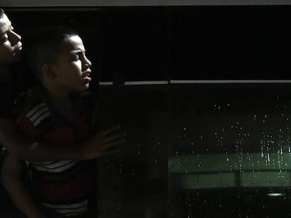 Dois garotos hondureños olham pela janela de um ônibus que abandona San Pedro Sula, e que viaja para a fronteira de Guatemala.