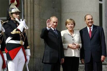 Vladímir Putin saluda junto a Angela Merkel y Jacques Chirac ayer en París.