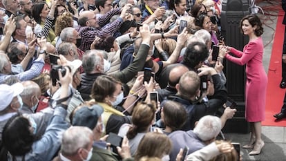 La presidenta de la Comunidad de Madrid, Isabel Díaz Ayuso, saluda a varios ciudadanos asistentes al homenaje a los héroes del Dos de Mayo en la Puerta del Sol de 2023.