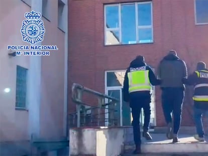 Dos policías, con uno de los detenidos de la red que falsificaba pasaportes covid y resultados negativos de PCR.