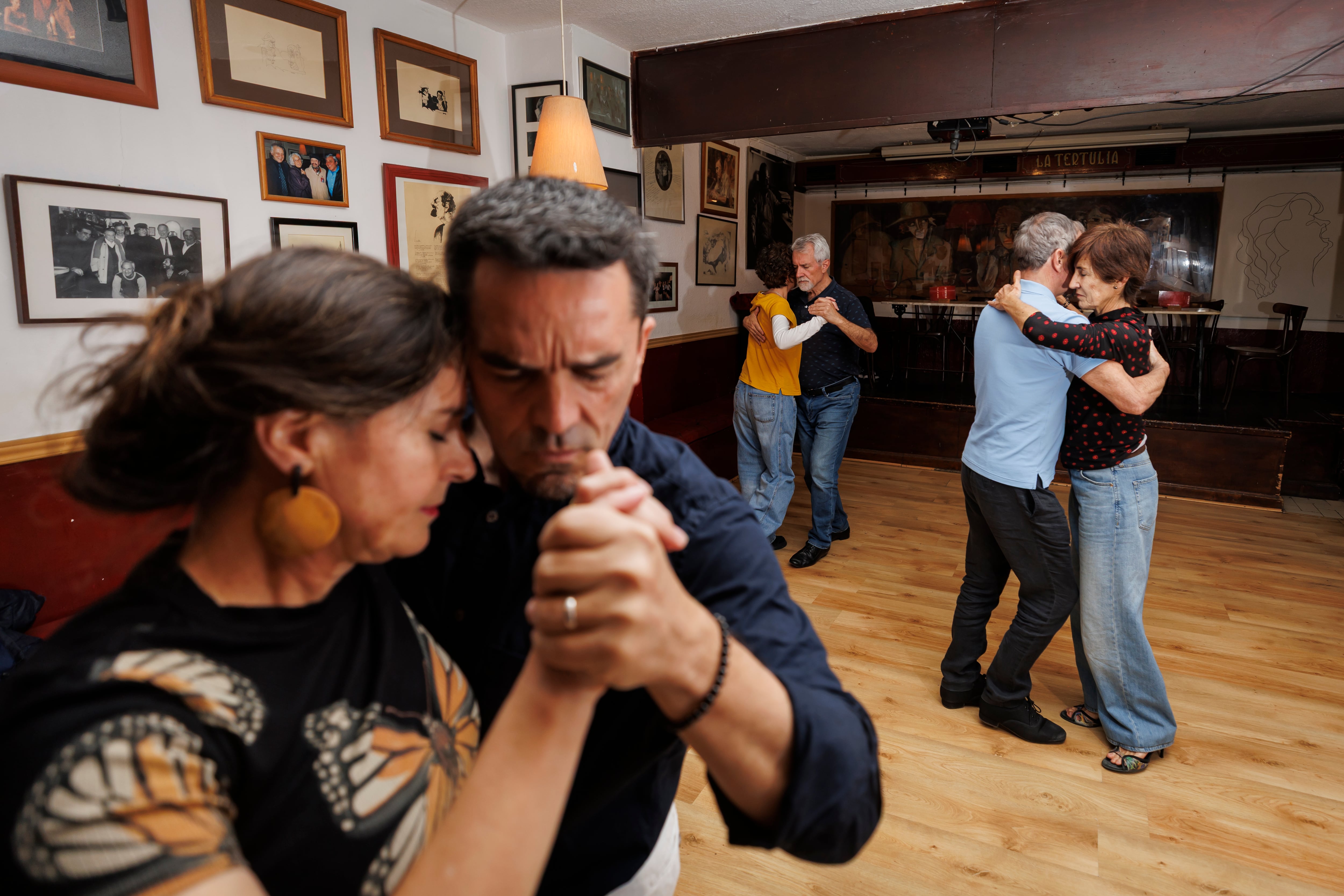 Tres parejas de tango danzan en La Tertulia.